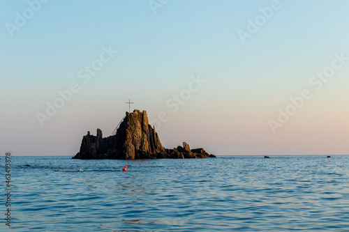 View of Asseu rock in Riva Trigoso (Italy) at sunset. Until 2020 it was possible to reach the rock through a boardwalk. Copy space. photo