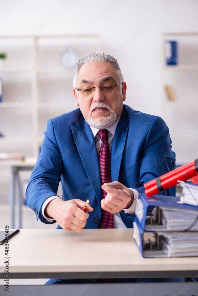 Fototapeta premium Old male employee with dynamite in the office