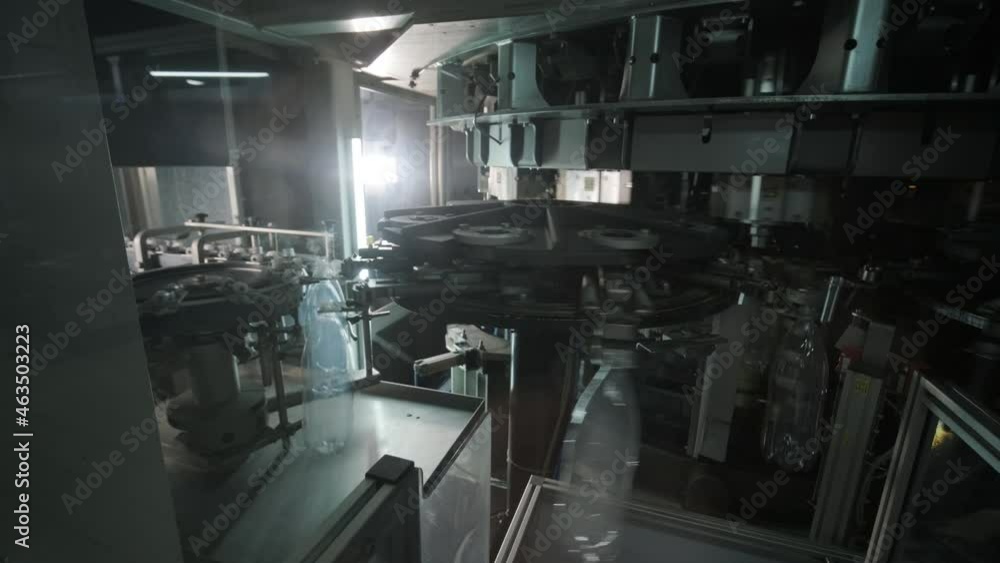 Automatic filling machine pours water into plastic PET bottles at modern beverage plant Automatic filling machine pours water into plastic PET bottles at modern beverage plant