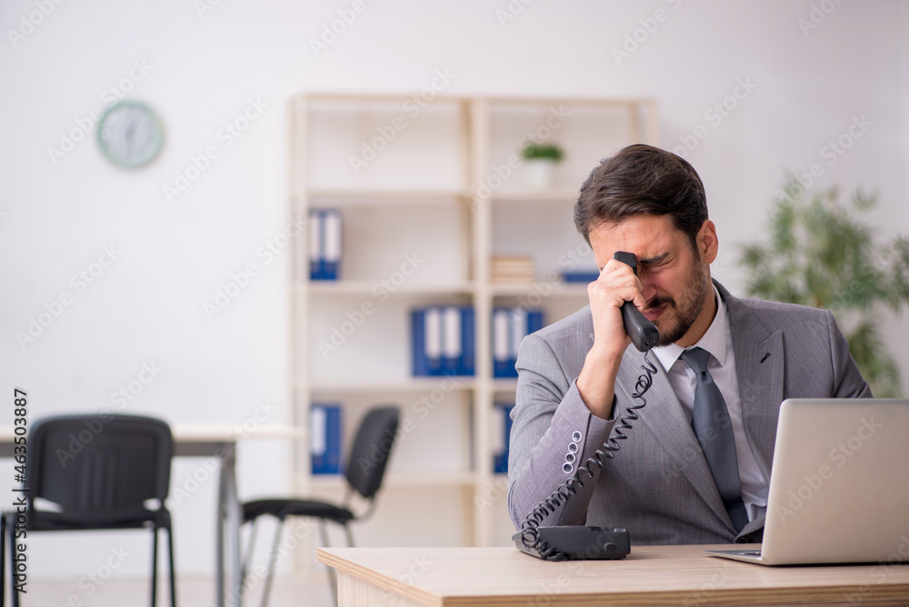 Obraz premium Young male employee and too much work in the office