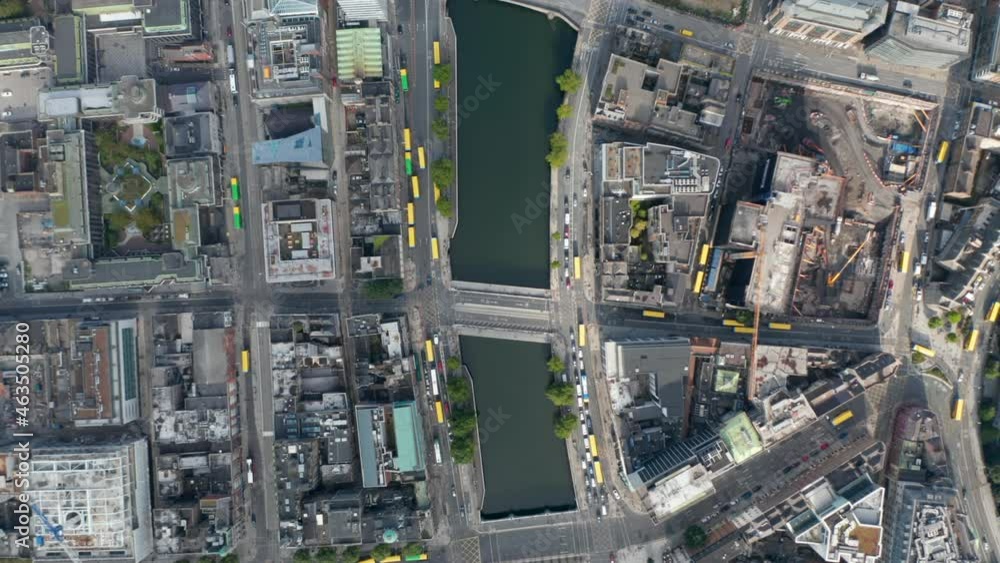 Aerial birds eye overhead top down view of water surface in town. Many yellow bus roofs in streets. Dublin, Ireland Aerial birds eye overhead top down view of water surface in town. Many yellow bus roofs in streets. Dublin, Ireland