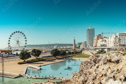 Intentionally blurred stone overlooking the town and clock tower of Figueira da Foz, PORTUGAL