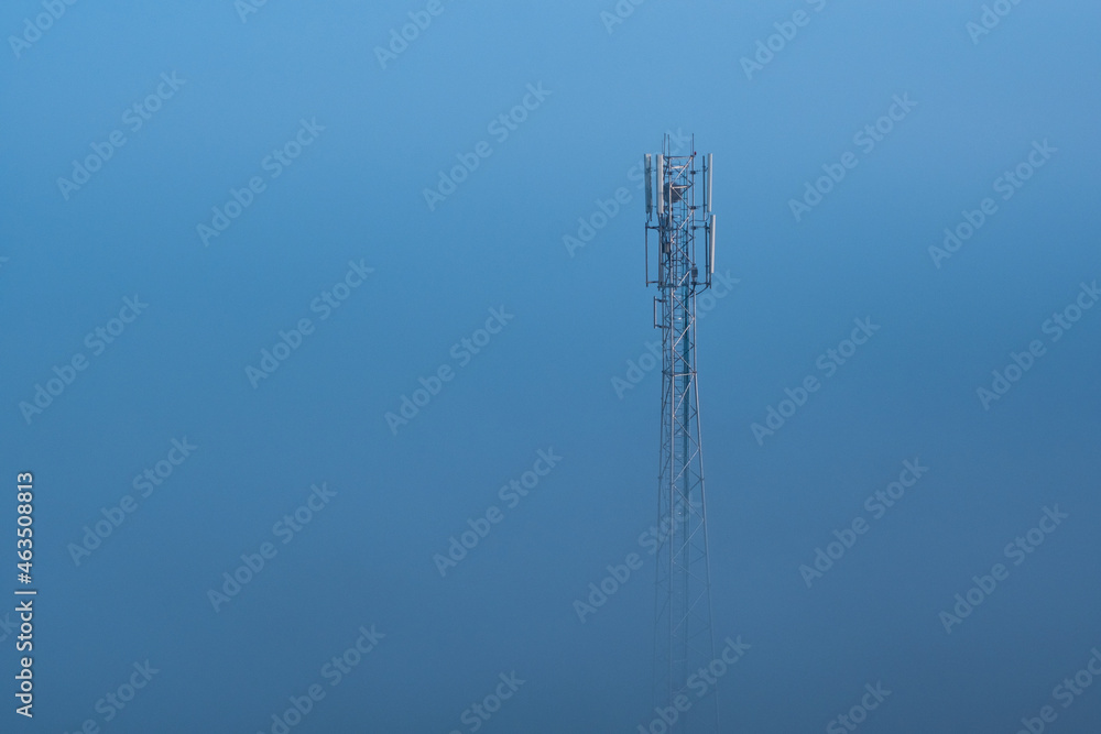 Mobile phone tower sticking out of dense fog. Mobile phone tower sticking out of dense fog.