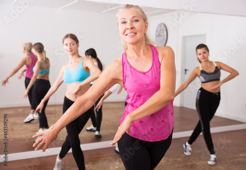 Group of active smiling people dancing together in dance studio. High quality photo