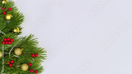 Christmas garland with holly berries and gold ornaments appear on left side. Stop motion