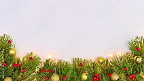 Christmas garland with gold ornaments and holly berries appear on bottom of white theme. Stop motion