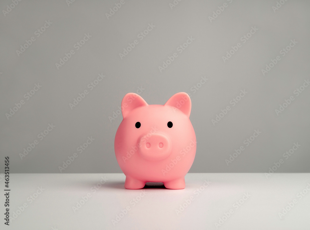 Pink piggy bank front view isolated on white table and grey background. Saving money and business investment concept. Pink piggy bank front view isolated on white table and grey background. Saving money and business investment concept.