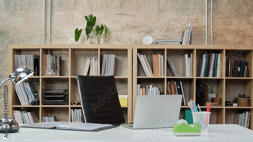Valokuva No people in a casual workplace, desk, and president chair in Architecture and Interior Design office, models, books, accessories, and equipment in the bookshelf decorate in modern-loft style