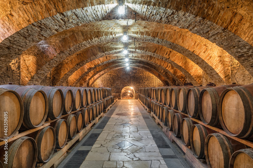 Fotótapéta Old wooden barrels with wine in the ancient medieval cellars