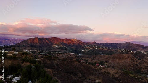 Hyperlapse drone shot over hills towards Hollywood sign, sunset in Los Angeles - Aerial view