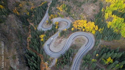 Cars driving on a curving mountain road forms a double S curve with four hairpin turns. Aerial drone footage of million dollar highway in southern Colorado. photo