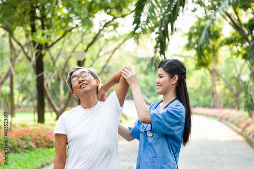 Asian young woman nurse taking care of an elderly man patient in the garden. Young happy doctor with older man outdoor with nature background.