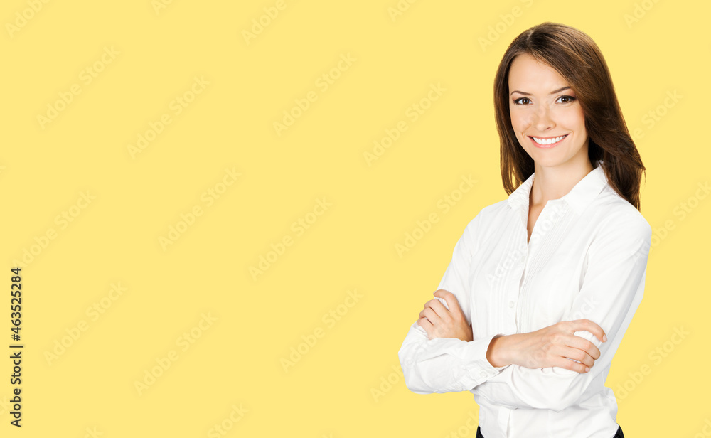 Portrait of smiling businesswoman in crossed arms pose, confident white clothing. Business concept. Brunette business woman, indoors. Yellow color background. Portrait of smiling businesswoman in crossed arms pose, confident white clothing. Business concept. Brunette business woman, indoors. Yellow color background.