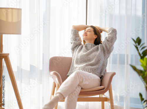 Obraz na plátně woman resting on armchair at home