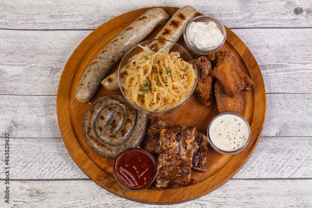 Meat plate with grilled sausages, ribs and chicken wings