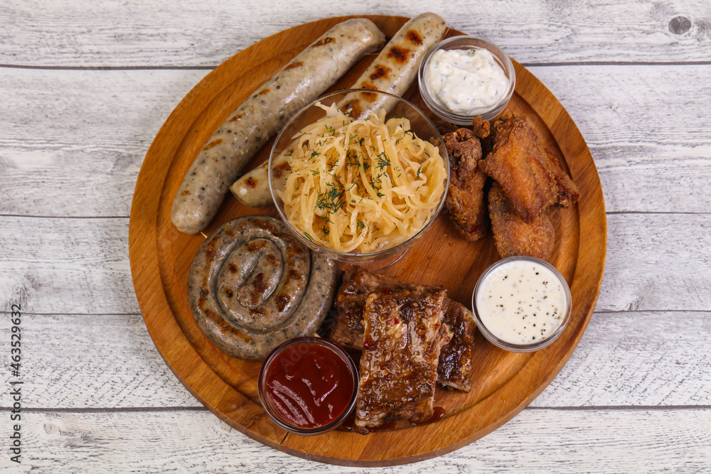 Meat plate with grilled sausages, ribs and chicken wings Meat plate with grilled sausages, ribs and chicken wings