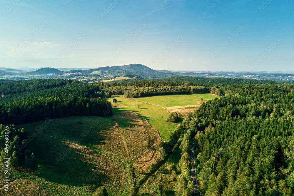 Beautiful landscape with mountains covered with forest and agricultural fields, aerial view.