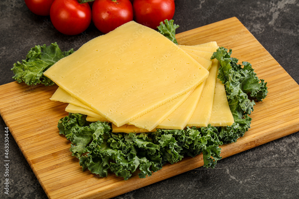 Sliced Gauda cheese over board Sliced Gauda cheese over board