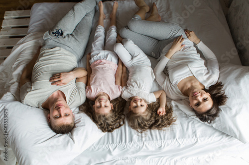 morning family: the children with parents playing in bed. waking up from a dream. I just woke up. love
