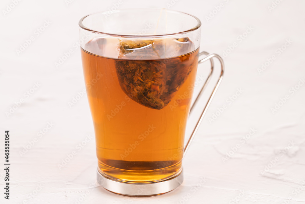 Steeping a herbal tea bag in a glass tea mug close up Steeping a herbal tea bag in a glass tea mug close up