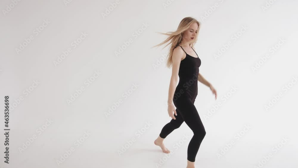 Sensual young girl doing a dance movement lifting her leg up during post-stretching classes in the studio. Harmony and balance concept Sensual young girl doing a dance movement lifting her leg up during post-stretching classes in the studio. Harmony and balance concept