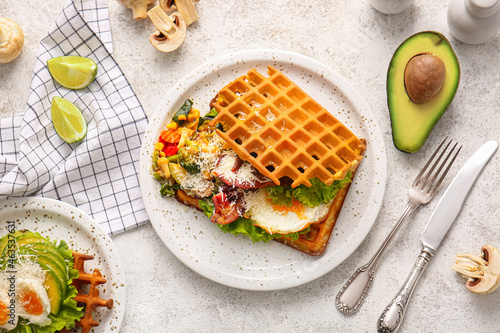 Composition with tasty Belgian waffles with vegetables on light background