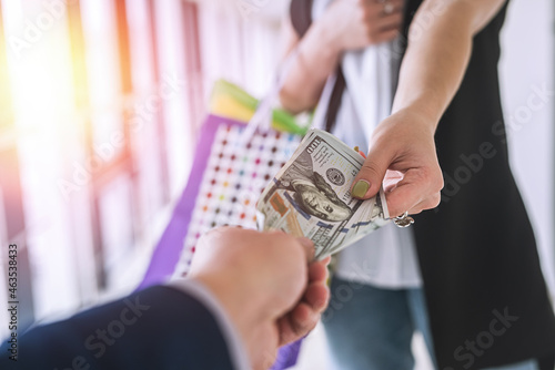 young woman girl count dollar money after purchases, holding package bag