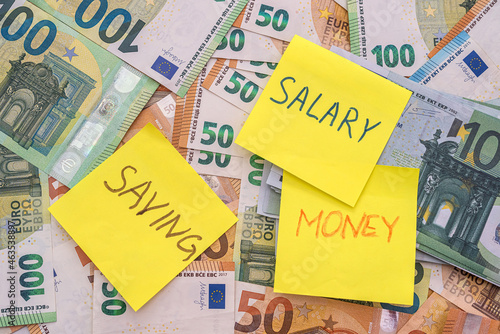salary wage saving write in notepad memo on euro banknote as background