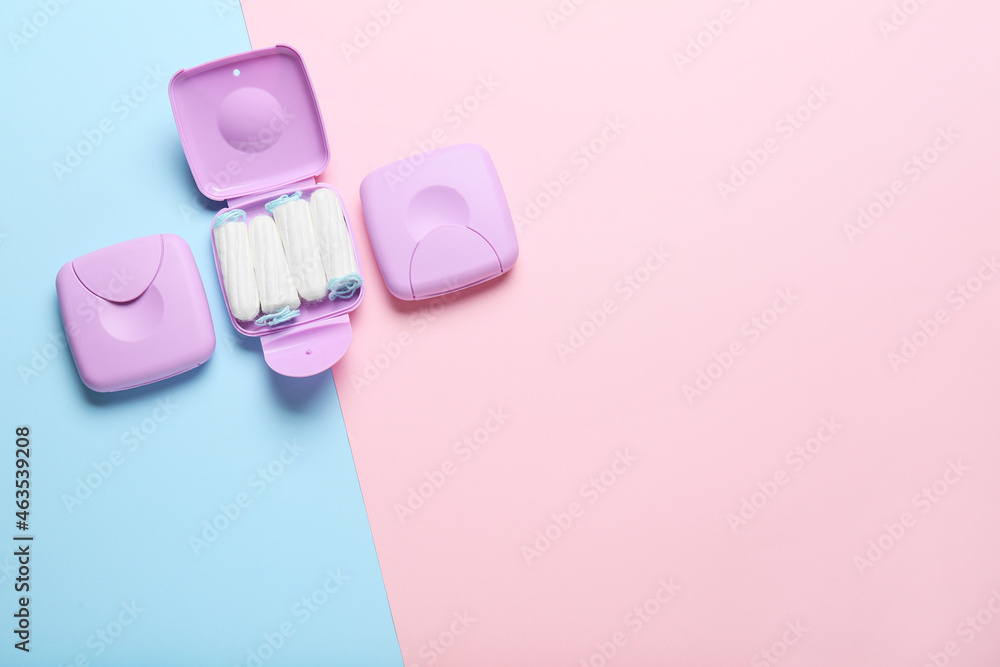 Tampons storage boxes on blue and pink background, top view