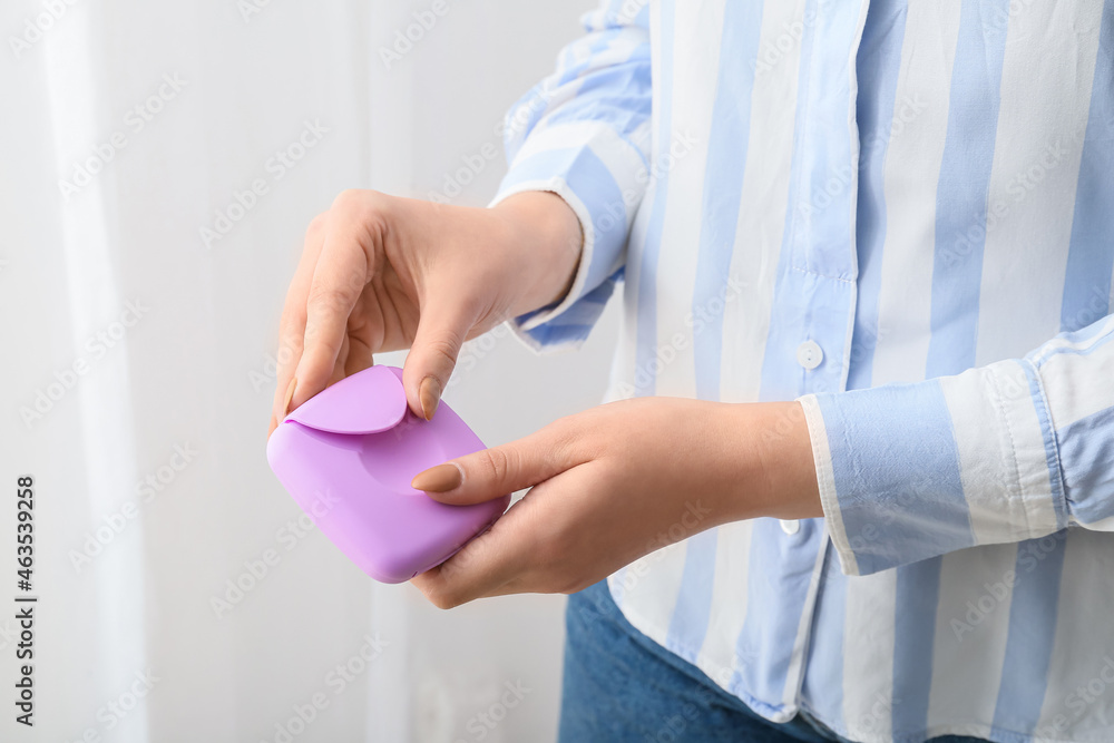 Woman holding plastic box for storing tampons, closeup