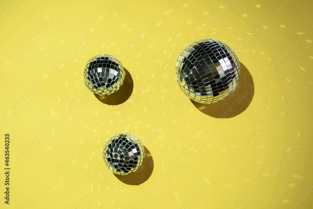 Background of colorful Christmas decor on a yellow background. Shiny balls on a yellow background.