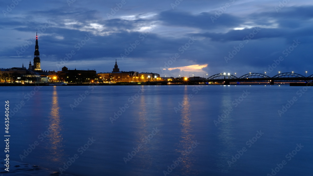 Autumn dawn in blue tones over old Riga reflection of night lights in the Daugava