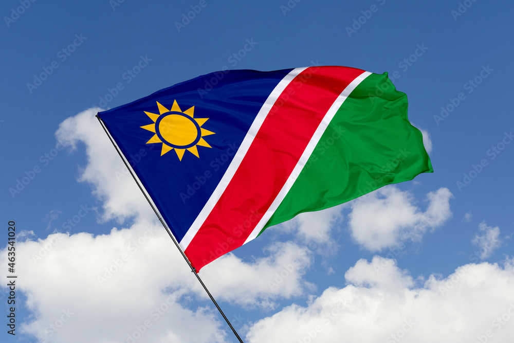 Namibia flag isolated on the blue sky background. close up waving flag of Namibia. flag symbols of Namibia. Concept of Namibia. Namibia flag isolated on the blue sky background. close up waving flag of Namibia. flag symbols of Namibia. Concept of Namibia.
