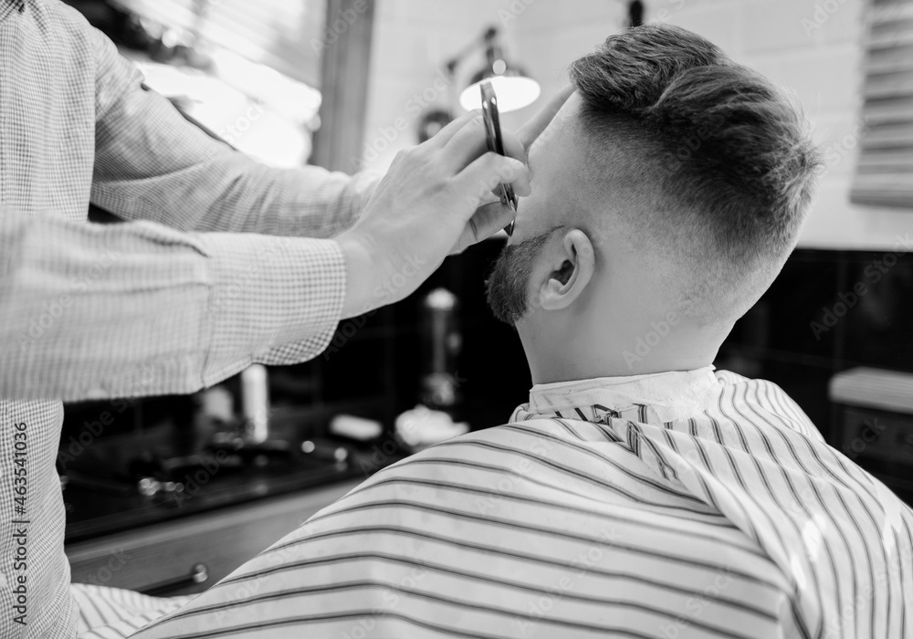 Fototapeta premium barber works with a straight razor