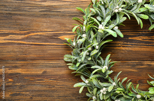 Simple mistletoe wreath on wooden background