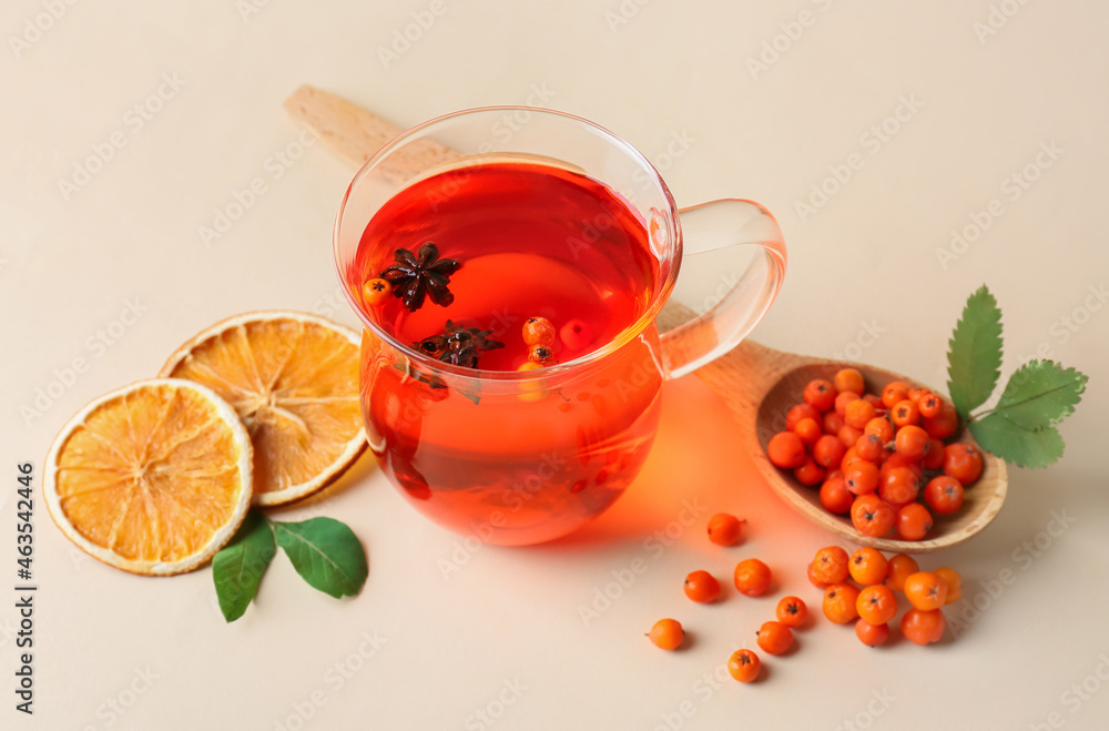 Glass cup of hot rowan tea and berries on color background Glass cup of hot rowan tea and berries on color background