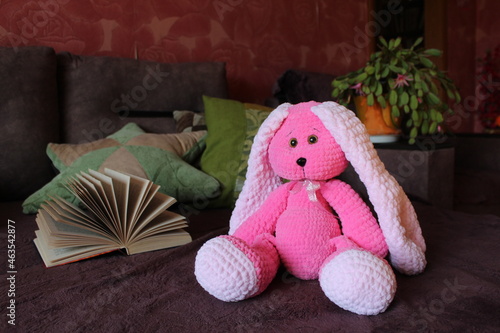 Pink knitted rabbit with a place for text. A toy hare.