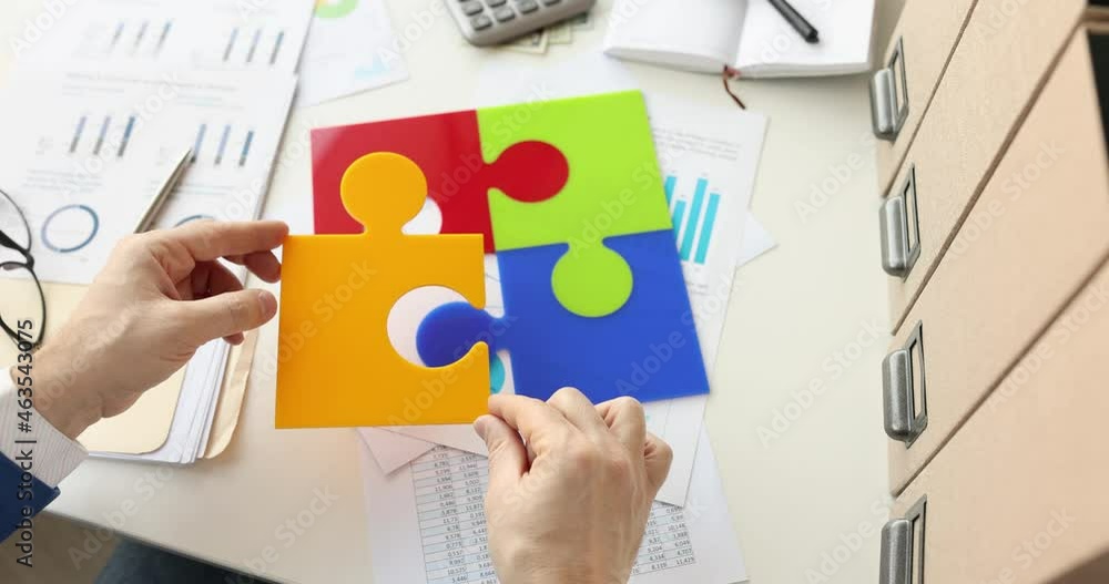 Businessman puts color puzzles on table in office 4k movie Businessman puts color puzzles on table in office 4k movie