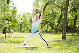 young pregnant woman doing stretching and yoga in a park. a healthy life
