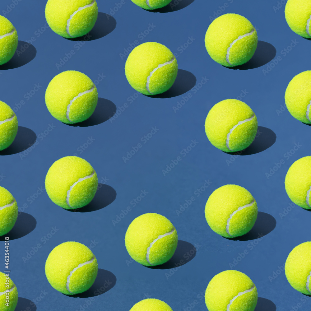 Arranged green tennis ball on blue background. Pattern. Copy space.