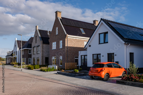 Newly build houses with solar panels attached on the roof against a sunny sky Close up of new building with black solar panels. Zonnepanelen, Zonne energie, Translation: Solar panel, Sun Energy photo