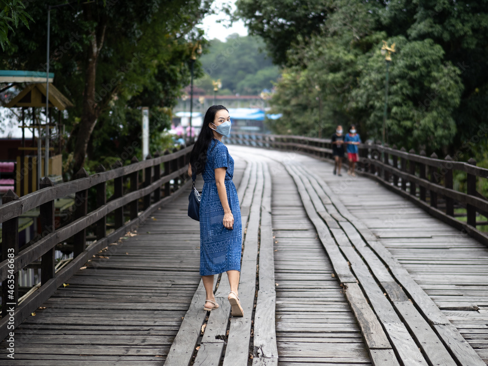 Young beautiful asian woman at Auttamanusorn Wooden Bridge (Sapan Mon) Kanchanaburi , Thailand when she have holiday vacation Young beautiful asian woman at Auttamanusorn Wooden Bridge (Sapan Mon) Kanchanaburi , Thailand when she have holiday vacation