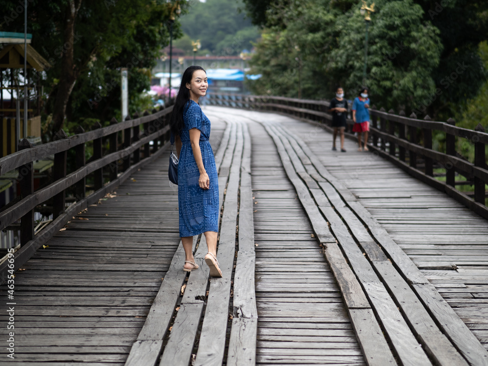 Young beautiful asian woman at Auttamanusorn Wooden Bridge (Sapan Mon) Kanchanaburi , Thailand when she have holiday vacation Young beautiful asian woman at Auttamanusorn Wooden Bridge (Sapan Mon) Kanchanaburi , Thailand when she have holiday vacation