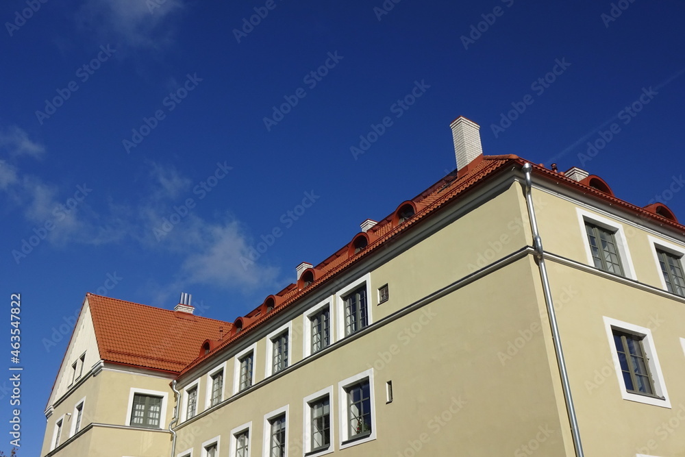 Close up of a house facade with red tiled roof. Clear blue sky background. Bottom up view. Sunny nautical day. Pelgulinna, Tallinn, Estonia, Europe. September 2021 Close up of a house facade with red tiled roof. Clear blue sky background. Bottom up view. Sunny nautical day. Pelgulinna, Tallinn, Estonia, Europe. September 2021