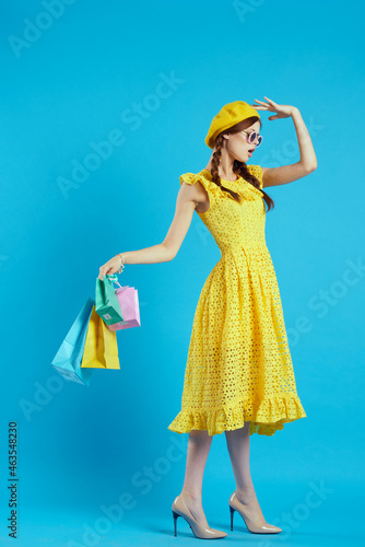 glamorous woman in a yellow hat Shopaholic fashion style isolated background