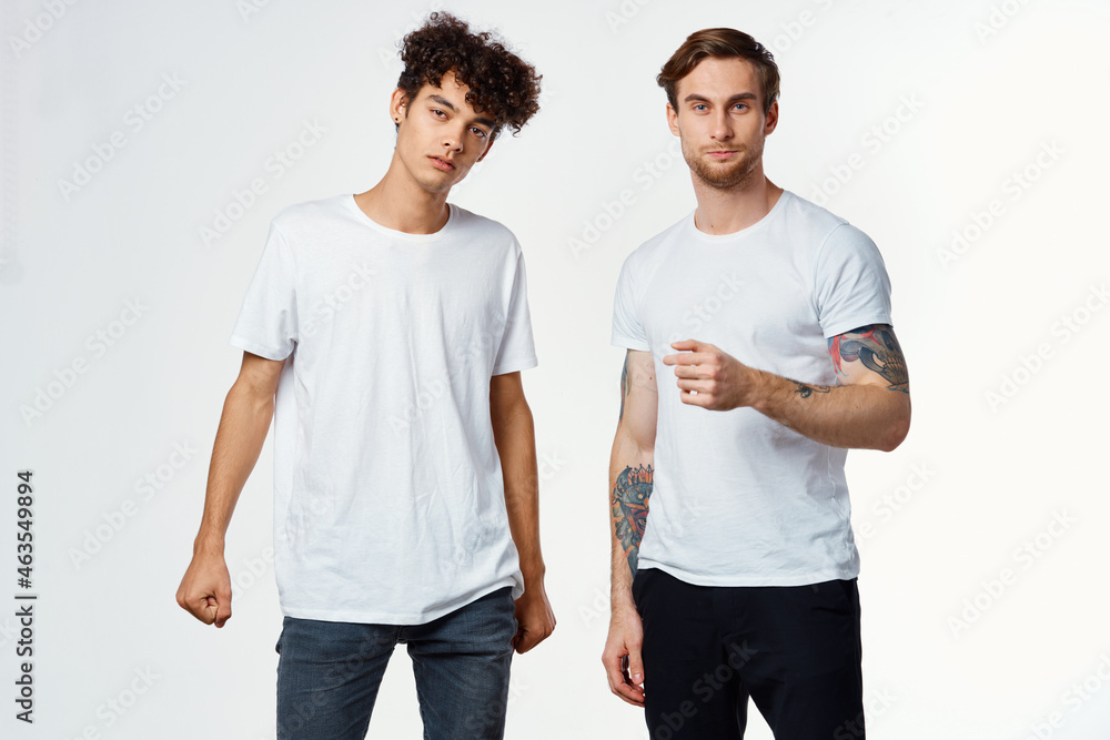 two men in t-shirts friendship communication light background two men in t-shirts friendship communication light background