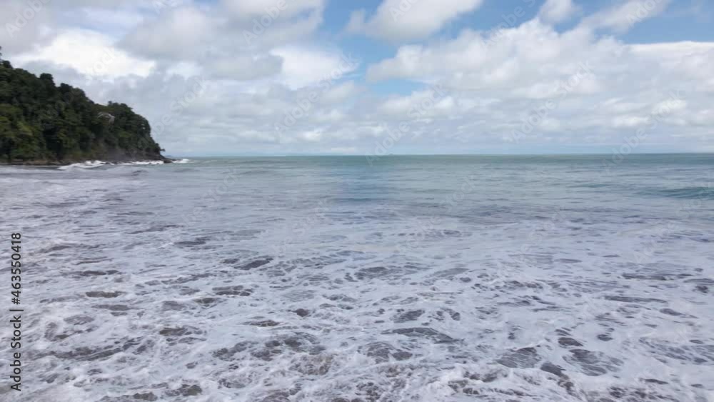 Aerial shot of a bird flying over the ocean with an exotic tropical beach Aerial shot of a bird flying over the ocean with an exotic tropical beach