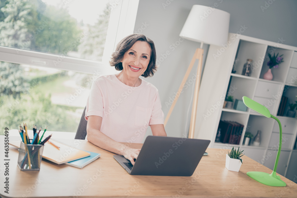 Photo portrait elder businesswoman typing message sitting at table working on laptop at home Photo portrait elder businesswoman typing message sitting at table working on laptop at home