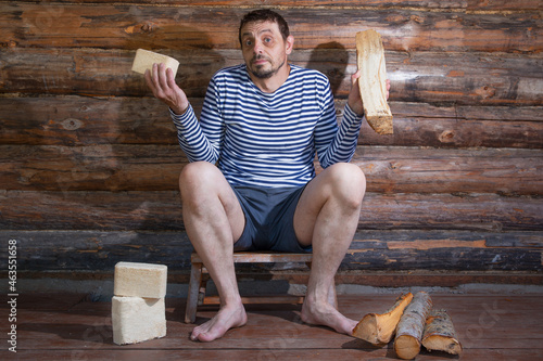 A European man, 40 years old, holds fuel briquettes made of pressed sawdust and chopped firewood. photo