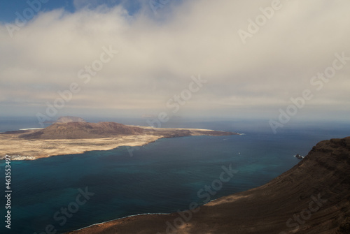 Aerial shot of cliffs in north of Lanzarote with view of La Graciosa, Canary Islands
